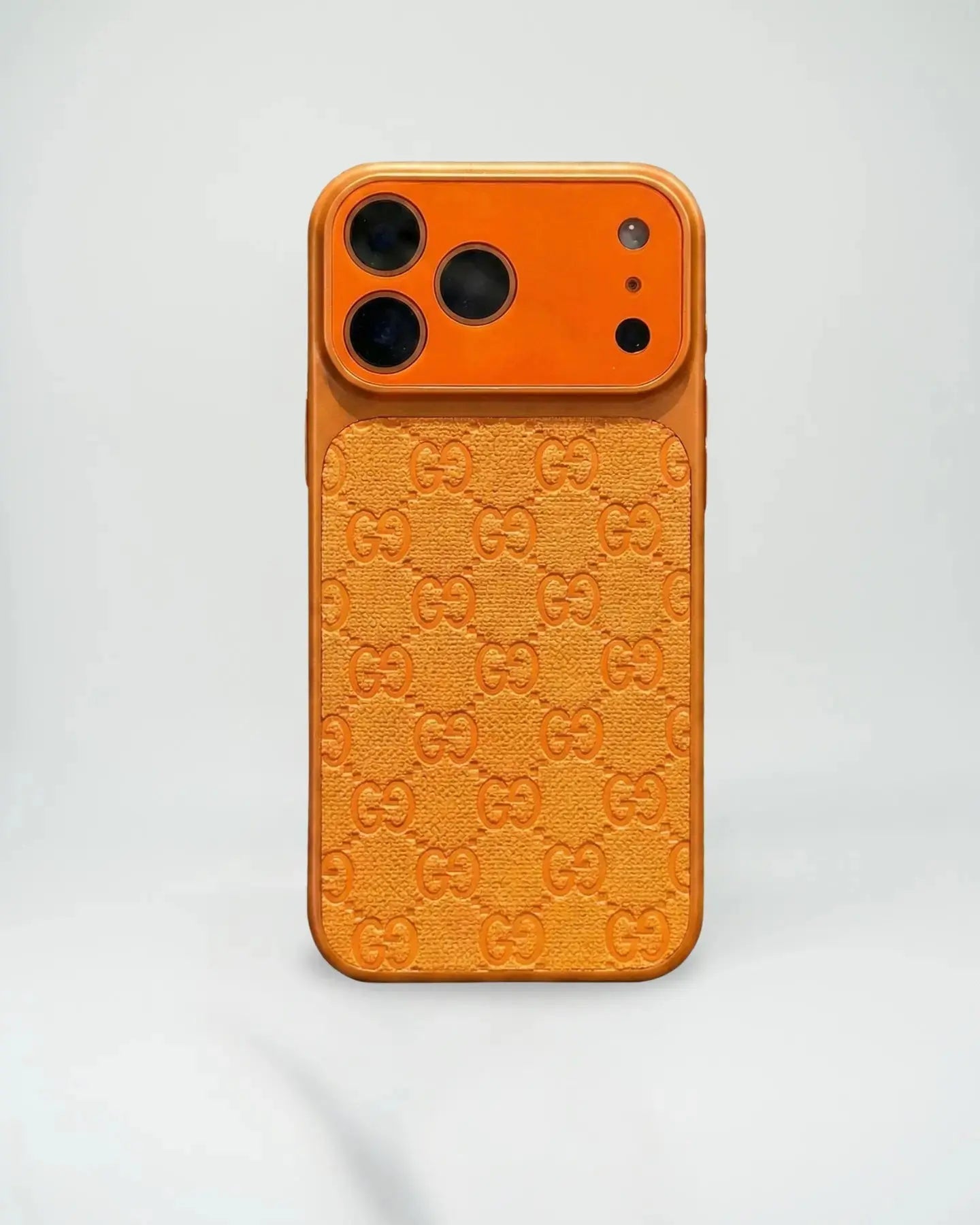 Orange phone case with Gucci logo pattern on a light gray background